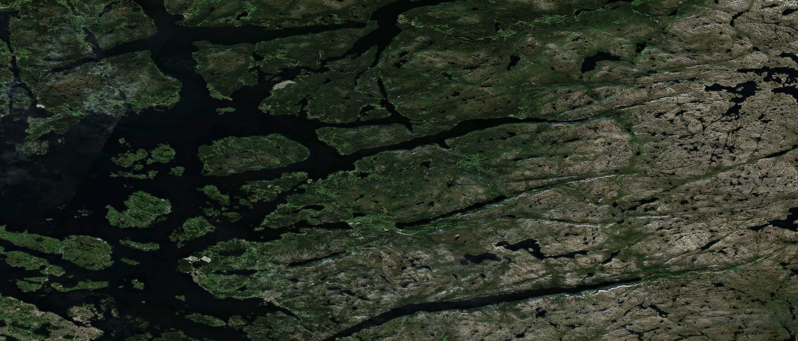 Sentinel-2 satellite view of the Norwegian coast, fjord water between forested skerries